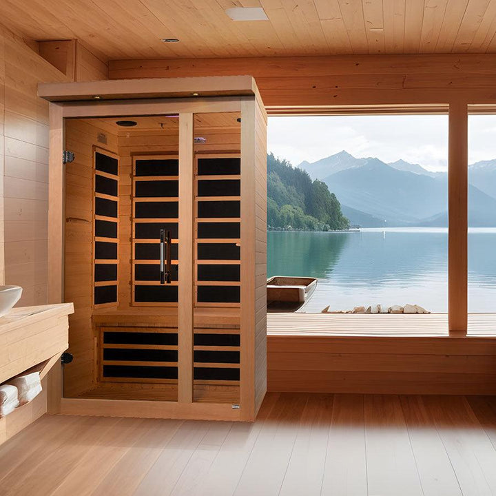 Dynamic Llumeneres 2-Person Ultra Low EMF FAR Infrared Sauna - Canadian Hemlock positioned in a scenic wood-paneled room overlooking a serene lake.