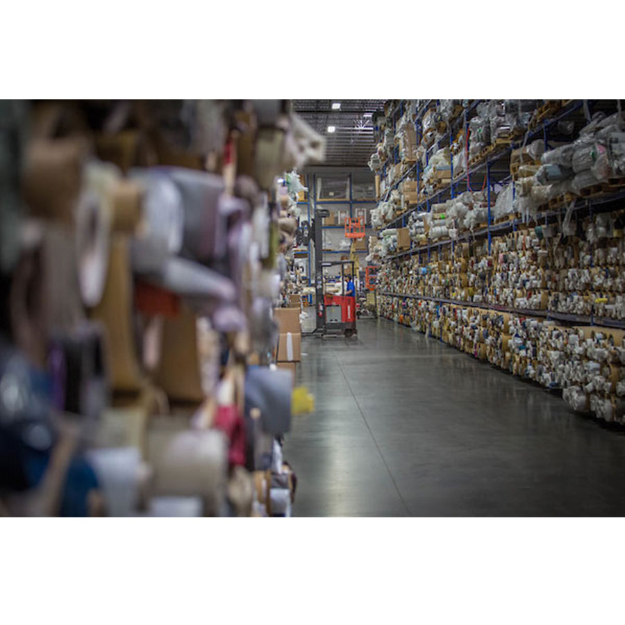 American Leather Comfort Air Rainier Solace Power Zero Gravity Recliner upholstery materials stored in organized warehouse aisle.