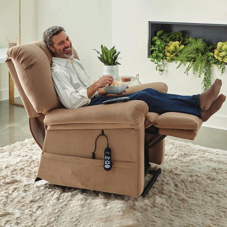 UltraComfort UC520-M Sol Medium Large 2 Zone (375#) Zero Gravity Lift Chair in Sinda Fabric Sparrow; lifestyle image showcasing a man enjoying his popcorn while sitting in a relaxed manner in a room with an inviting vibe from Wish Rock Relaxation